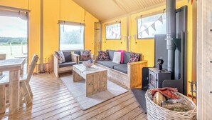 Un intérieur de chalet chaleureux avec un canapé, une table basse et un poêle à bois.