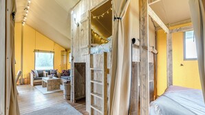 Une pièce chaleureuse avec des murs en bois, un canapé, un lit et une fenêtre.