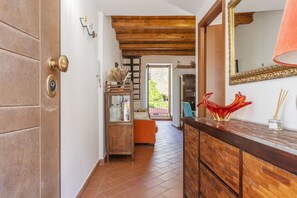 Un couloir avec une porte en bois, un miroir et un meuble en bois.