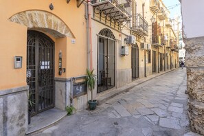 A narrow street with buildings featuring arched doorways and balconies. - Apartment 'Mau House 44' with Private Terrace, Wi-Fi and Air Conditioning (Palermo)