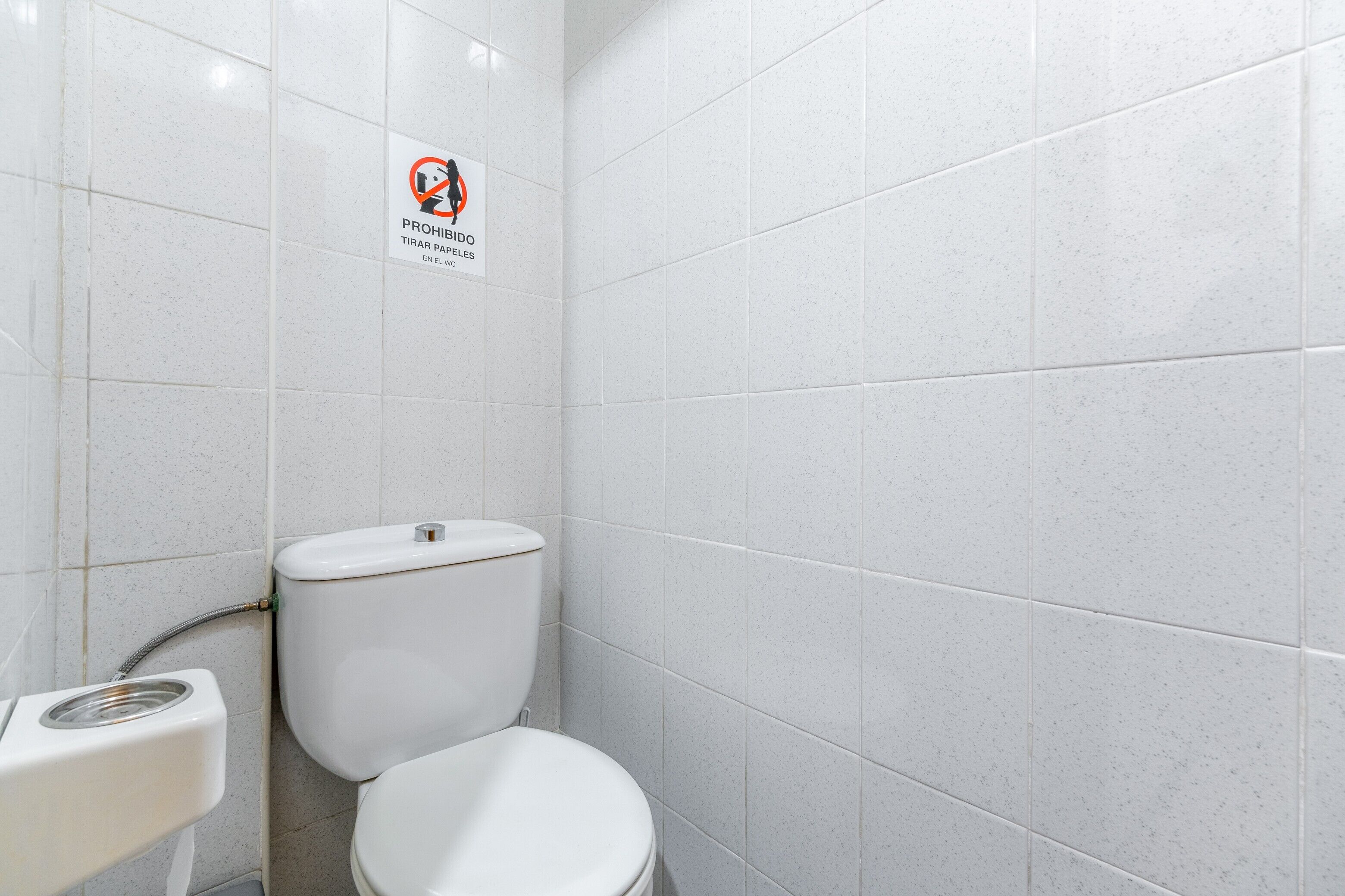 Une salle de bain équipée de toilettes, d’un bidet et d’un panneau indiquant qu’il est interdit de fumer.