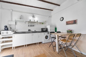 A compact kitchen with a washing machine, microwave, and sink.