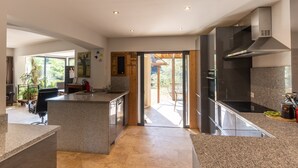 A modern kitchen with granite countertops, stainless steel appliances, and a view to the outside. - Villa "Luminières I" with Mountain View, Private Pool & Wi-Fi (Les Salelles)