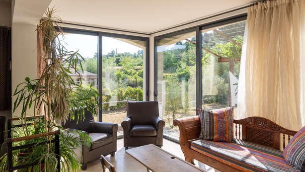A modern living room with large windows, a sofa, a chair, and a table. - Villa "Luminières I" with Mountain View, Private Pool & Wi-Fi (Les Salelles)