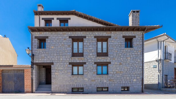A stone building with multiple windows and a staircase leading to the entrance. - Holiday Home 'Casa Alval' with Mountain View, Wi-Fi and Air Conditioning (VILLACASTIN)