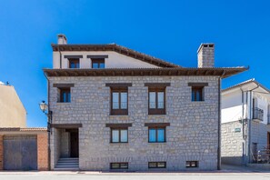 A stone building with multiple windows and a staircase leading to the entrance. - Holiday Home 'Casa Alval' with Mountain View, Wi-Fi and Air Conditioning (VILLACASTIN)