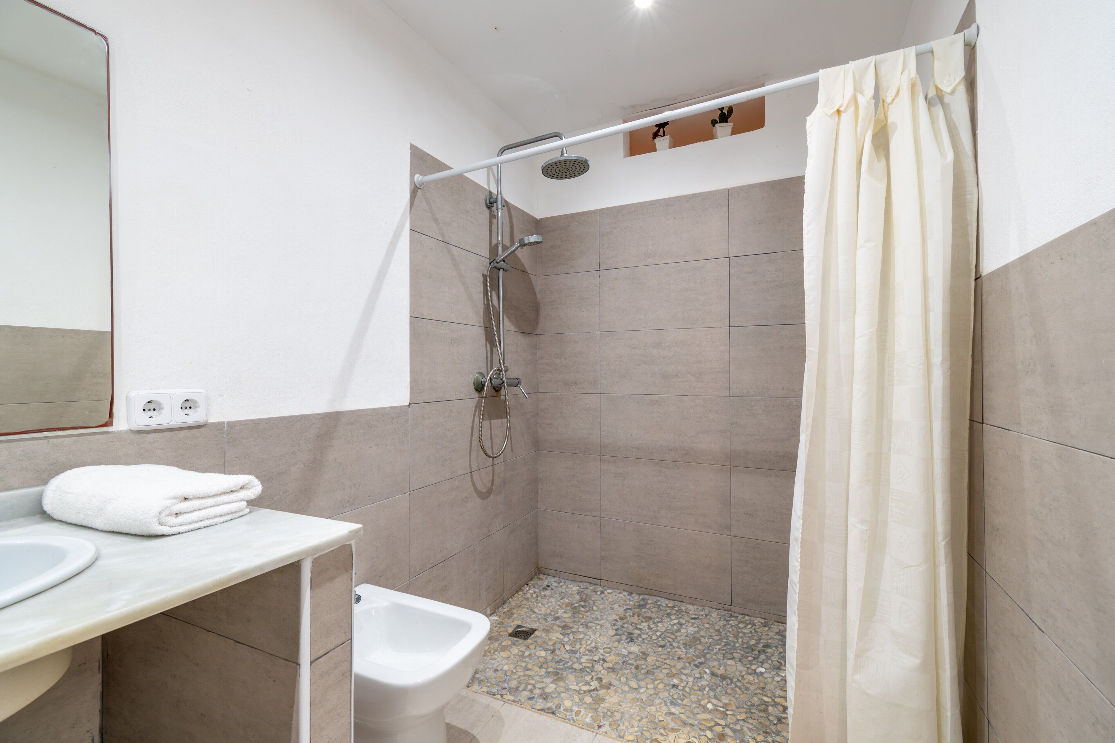 Un baño con ducha, lavabo y bidé.