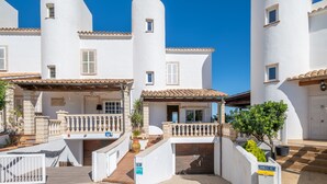 A white building with a balcony, a gate, and a sign with the number 216. - Holiday Home 'Es Mirador' with Sea View, Wi-Fi and Air Conditioning (Son Serra de Marina - Santa Margalida)