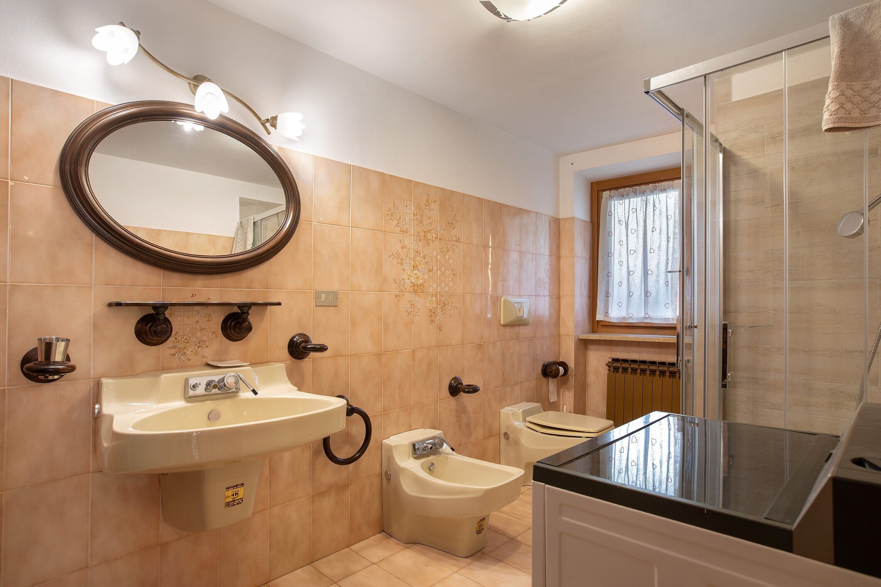 Un baño con lavamanos, bidé, inodoro y ducha.