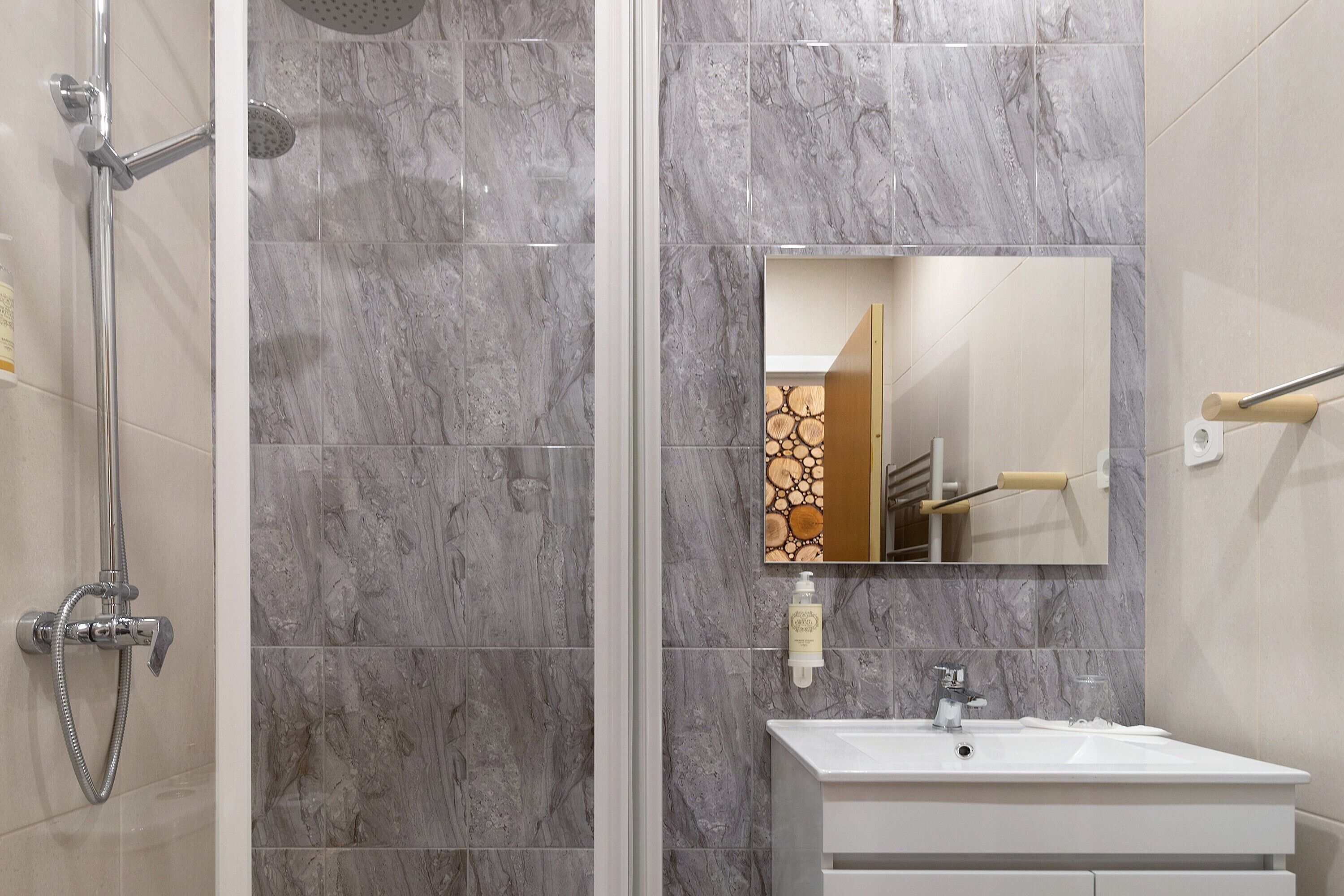 Une salle de bain avec une douche, un lavabo et un miroir.