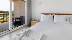 Een hotelkamer met een bed, een nachtkastje, een stoel en uitzicht op de omgeving.