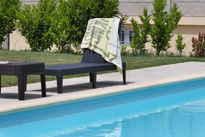 A poolside lounge chair with a towel, a book, and a pool. - Holiday Bedroom 'Quarto Duplo Terreio' with Mountain View, Wi-Fi and Air Conditioning (Lama de Ouriço)