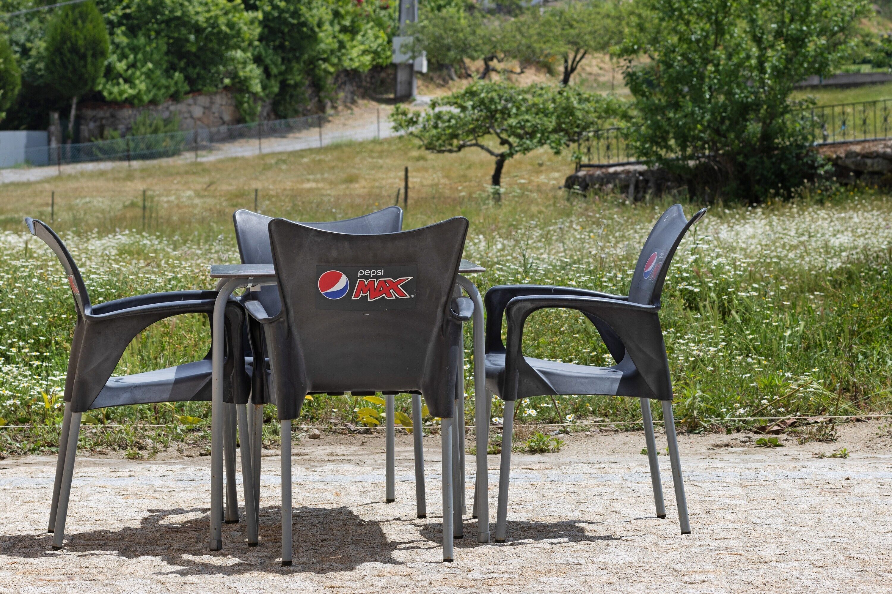 A table with four chairs, each chair has a Pepsi Max logo.