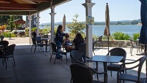 An outdoor patio with tables and chairs, overlooking a lake. - Lovely Condo close to town with Forest View (Longview)