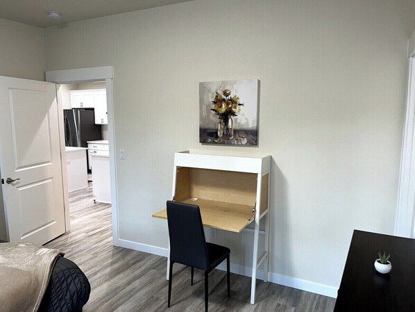 A compact room with a white desk, a black chair, and a small potted plant. - Forest-View 4BR w/ 3 Kings, Fire Pit & Ping Pong (Longview)
