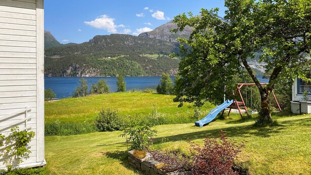 Una casa con vista a un lago y montañas.