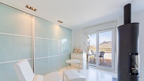 Ein modernes Interieur mit einer Glaswand, einem schwarzen Herd und einer Sitzecke.