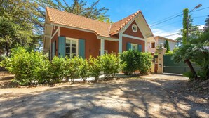Une maison avec un toit en tuiles, un porche à l’avant et une allée.
