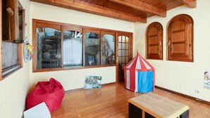 A room with wooden beams, large windows, a red bean bag, a small table, and a tent. - Country House 'Cal Eloi Janet' with Mountain Views, Private Pool and Wi-Fi (Sant Marti Sarroca)