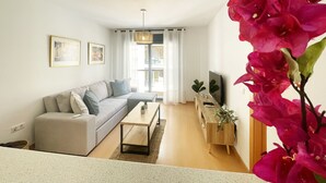 Ein modernes Wohnzimmer mit Sofa, Couchtisch und TV-Schrank.