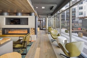 A modern lounge area with a fireplace, comfortable seating, and large windows offering views of the city. - Perfect for Bleisure Travellers! Restons Hotspot nr Shops (Reston)