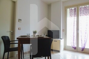 A dining area with a table, chairs, and a television. - Homiday - Felicioni Alba, 2-room apartment on the 1st floor (Alba Adriatica)