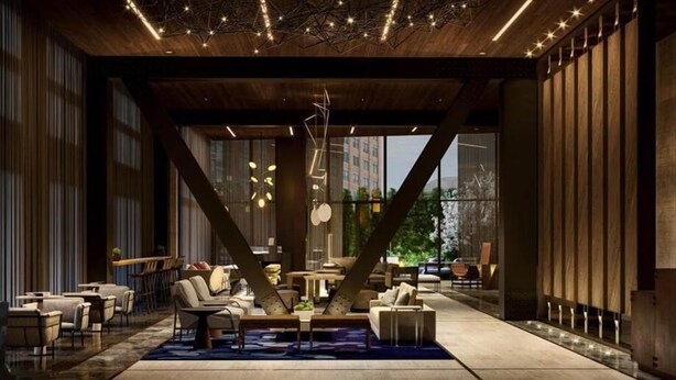 A modern lounge area with a geometric ceiling design, large windows offering a view of the city, and a variety of seating arrangements.