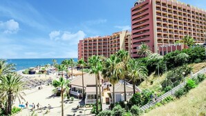Ein Hotel mit mehreren Etagen, einer Strandlage und Blick auf den Ozean.