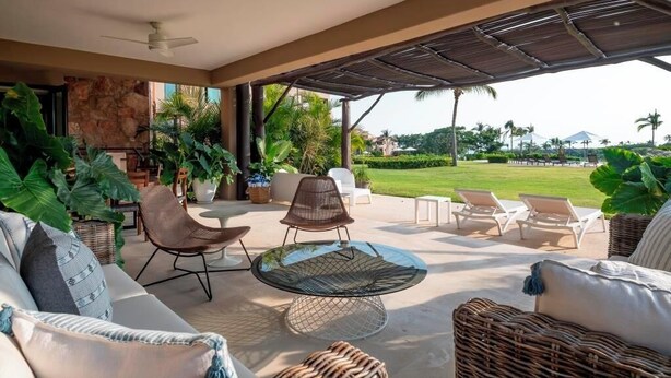 An outdoor lounge area with a round glass table, wicker chairs, and a sofa. - Your Private Escape in Punta Mita/Premier membership, HK & Concierge Service (Hacienda de mita)