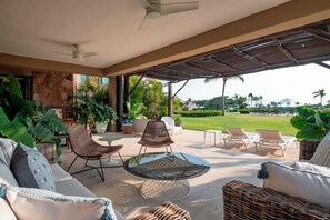 An outdoor lounge area with a round glass table, wicker chairs, and a sofa. - Your Private Escape in Punta Mita/Premier membership, HK & Concierge Service (Hacienda de mita)