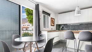 A modern kitchen with white cabinets, a black countertop, and a hanging light fixture. - Holiday Home 'Bright' with Mountain View, Balcony and Wi-Fi (Agaete)