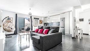 A modern living area with a grey sofa, a dining table, and chairs. - Holiday Home 'Bright' with Mountain View, Balcony and Wi-Fi (Agaete)