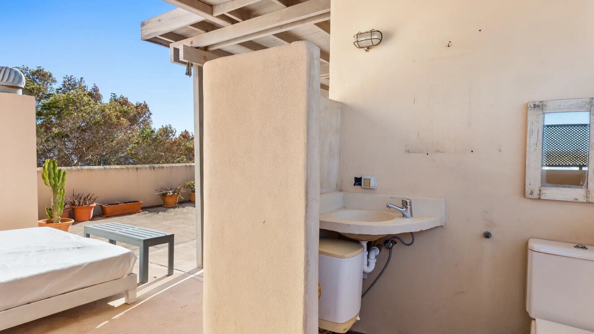 A compact bathroom with a sink, toilet, and a small window.