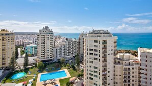 Un hôtel de grande hauteur doté d’une piscine, de nombreux balcons et offrant une vue sur la mer.
