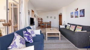 Un salon comprenant un canapé, une table basse et un coin repas avec des chaises et une table.