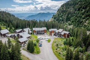 A lodge with multiple buildings, a parking area, and a mountainous backdrop. - Apartment 'Fleury' with Mountain View and Balcony (Mieussy)