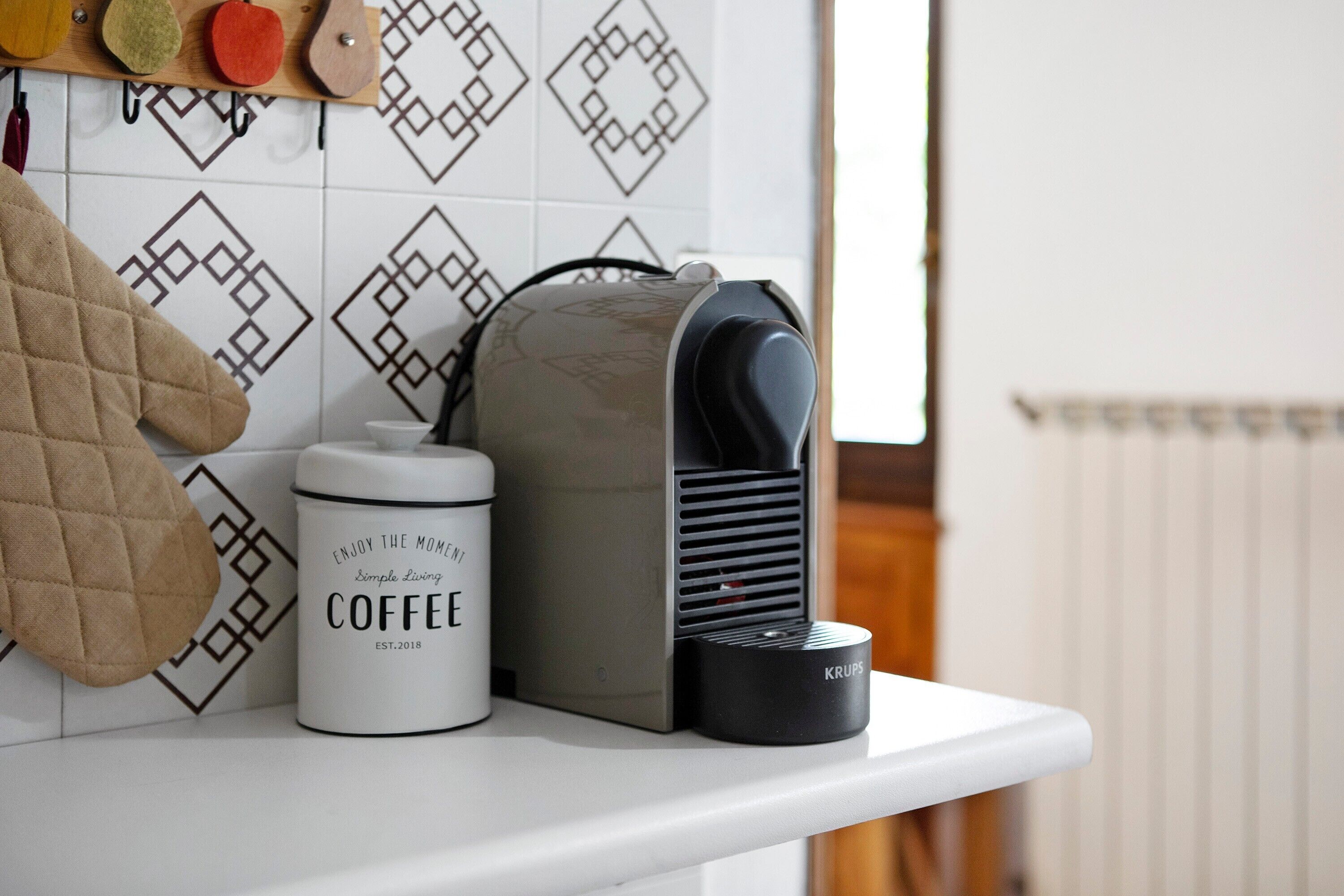 Een keukentafel met een koffiezetapparaat, een waterkoker en een mok.