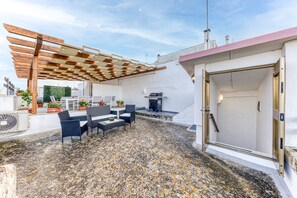 An outdoor patio with a pergola, seating area, and a grill. - Apartment 'Mia' with Shared Terrace and Air Conditioning (Presicce-Acquarica)
