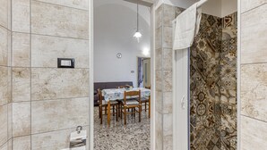 Une salle de bain avec une baignoire, une douche et un carrelage au sol.