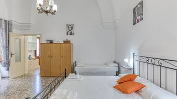 A bedroom with a bed, a wardrobe, a mirror, and a chandelier.
