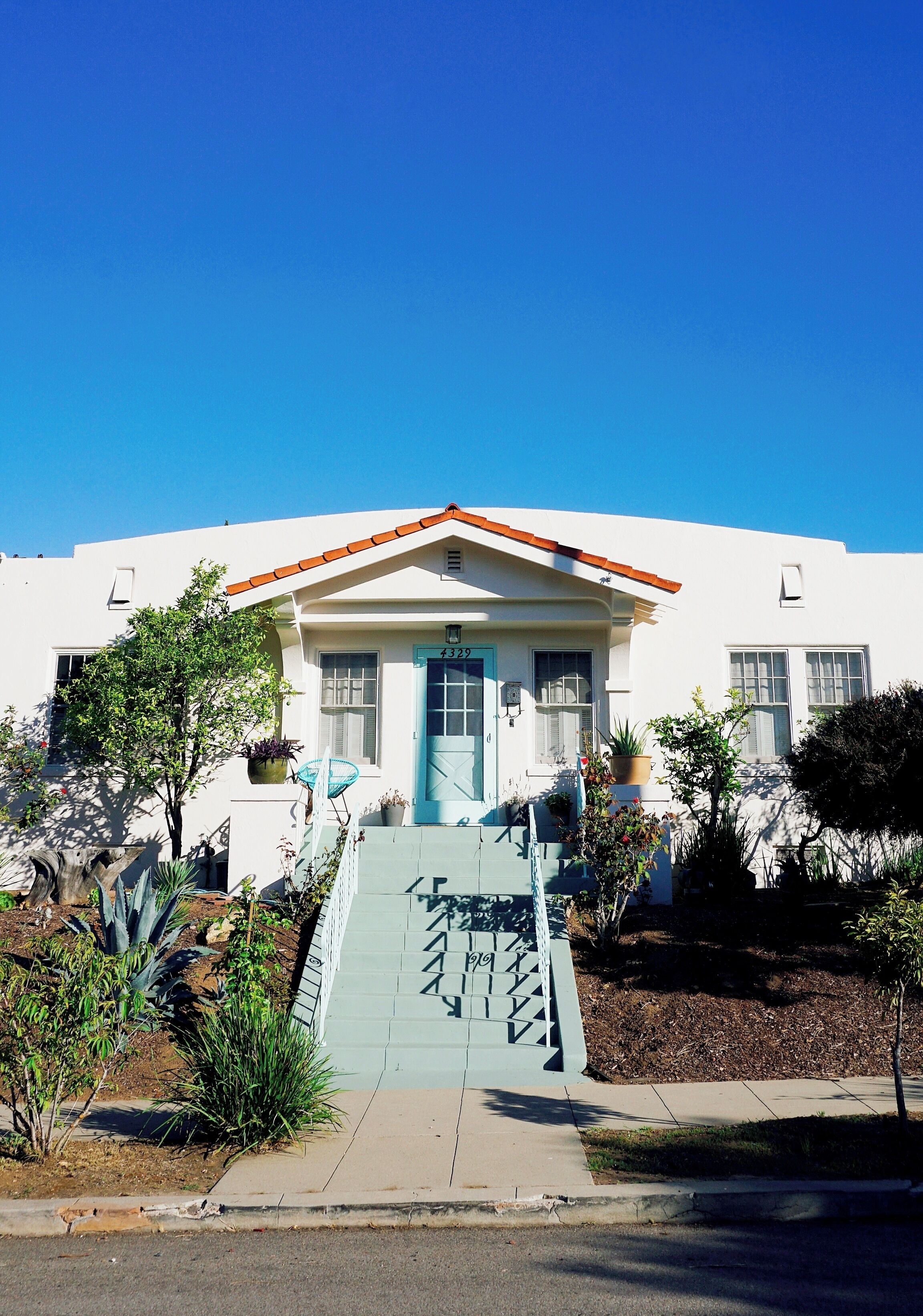 Spanish-style architecture amidst a flourishing garden of flowers and trees