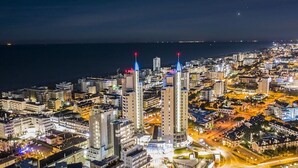 Un paisaje urbano nocturno con edificios destacados y agujas iluminadas.