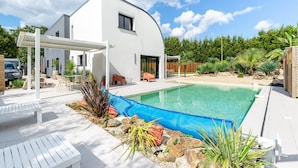 A modern house with a swimming pool, white exterior, and a covered patio area. - Modern Villa with Private Pool (Saint-Aignan-Grandlieu)