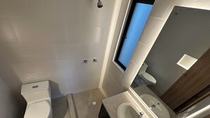 A modern bathroom with a toilet, sink, and shower.