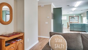 A living room with a chessboard, a mirror, and a couch with a pillow. - 1 Block to Shore: Fort Myers Beach Retreat (Fort Myers Beach)