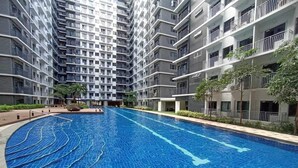 A modern residential building with a central swimming pool. - Shore 3 Residences Authentic Japanese-Style Bedroom with Pool View - MOA Complex (Pasay)
