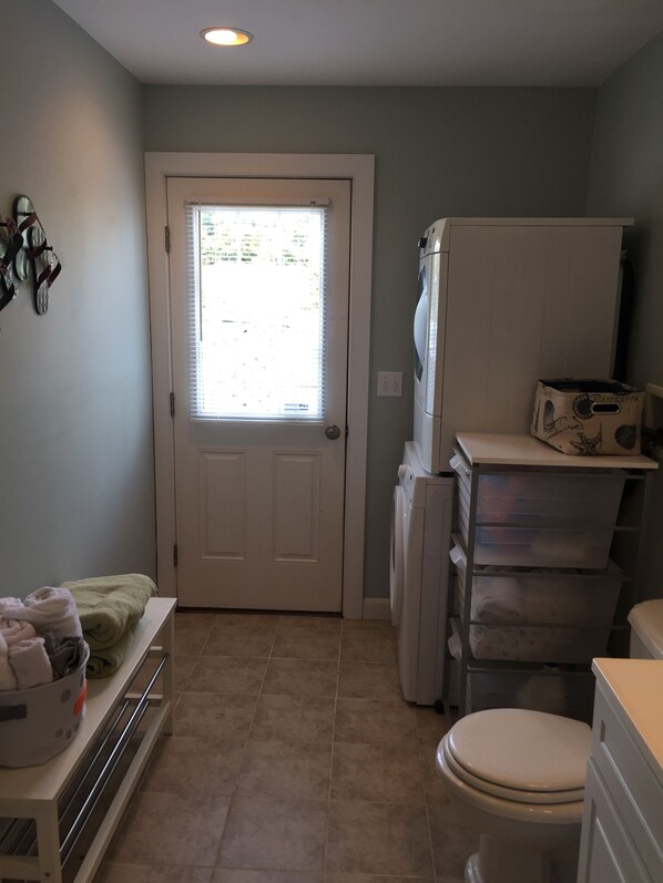 Une petite salle de bain comprenant des toilettes, un lave-linge et un lavabo.