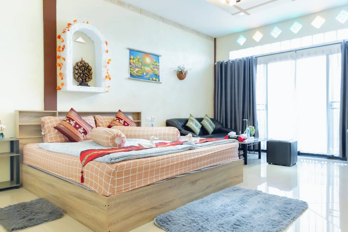 Une chambre moderne avec un grand lit, un canapé et une table à manger.