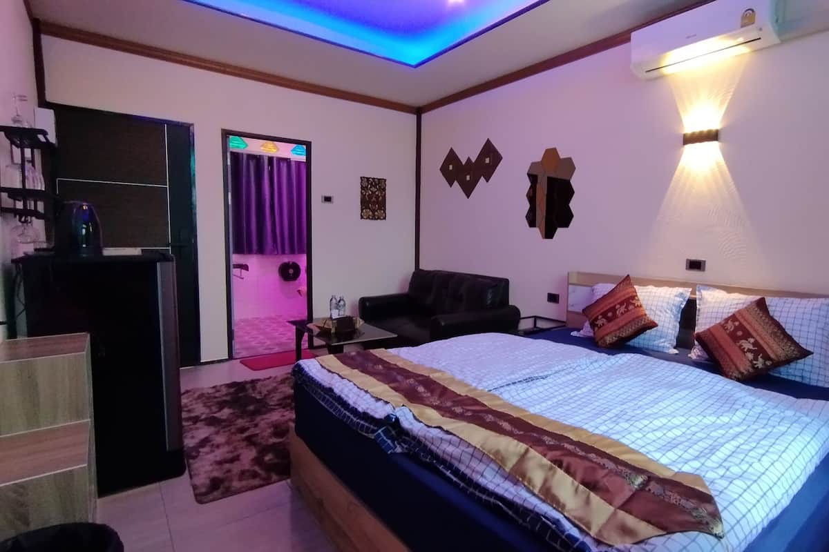 Une chambre à coucher comprenant un lit, un bureau, une chaise et une armoire.