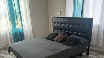 Une chambre à coucher avec un lit, un sol en marbre et des rideaux.